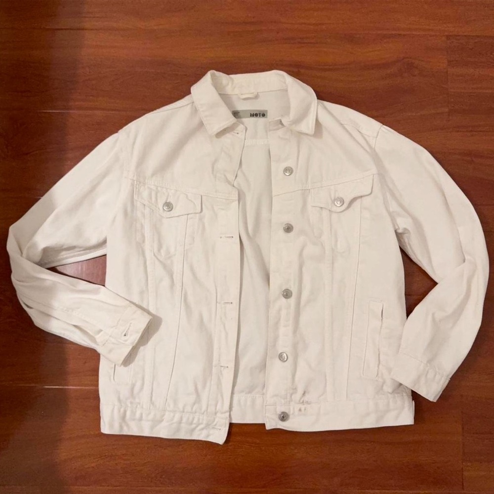 White oversized denim jacket with silver buttons and two front pockets